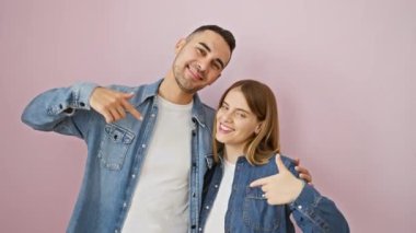 Kot gömlekli, gururlu ve mutlu, kendini gösteren pembe izole edilmiş arka planda yayılan güzel çift..