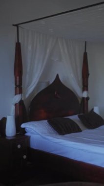 Zarif dört posterli bir yatak odası, kubbeli, tüylü yastıklar, ahşap mobilyalar, sükunet ve atmosferik iç tasarım kavramları için konfor..