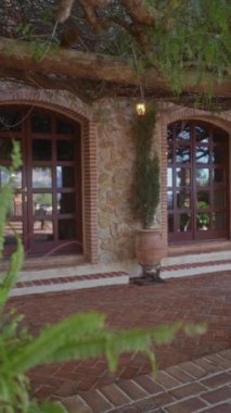 Terracotta tencereleri, tuğla kaldırımları ve kırmızı pencere çerçeveleriyle Akdeniz tarzı cephe