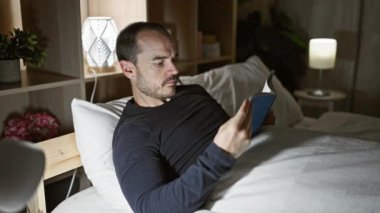 Sakallı, kel, gece vakti evde lamba açık kitap okuyan İspanyol bir adam..