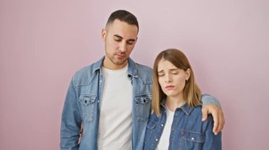 Üzüntülerini ifade eden kot gömlekli güzel bir çift pembe arka planda yalnız dikiliyor, stresli ve endişeli, depresif bir ifade sergiliyor, ağlıyor ve öfke takınıyorlar.
