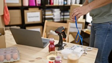 Bağış merkezi deposunda dizüstü bilgisayarla çalışan sakallı gönüllü adam..