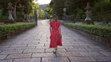 Işıldayan İspanyol kadın, ışıl ışıl güzel, geleneksel bir elbiseyle, Legion Kyoto 'nun kaldırımlı sokaklarında dönüyor, eski Japon kasabasını bulaşıcı neşe ile tutuşturuyor.