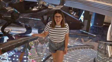 Lüks yolcu gemisinde gözlüklü, gülümseyen kadın.