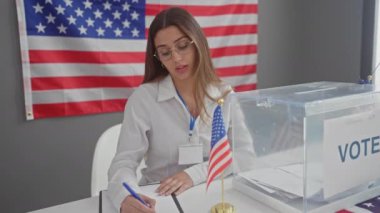 Amerika Birleşik Devletleri oy kullanma merkezinde çalışan genç bir İspanyol kadın. Amerikan bayrakları ve oy sandığıyla..