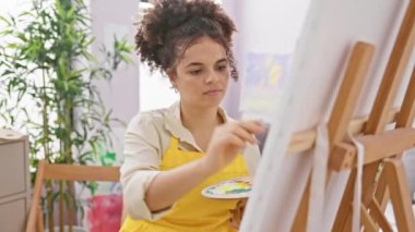 Neşeli İspanyol sanatçı, kıvırcık saçlı mutlu bir el hareketiyle seni stüdyoya davet ediyor ve 