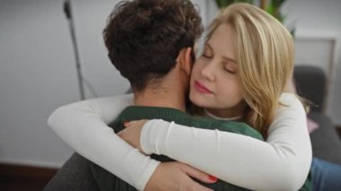 Modern bir oturma odasında bir erkekle kadın arasında sevgi dolu bir kucaklaşma evdeki sevgi, rahatlık ve ilişkiyi tasvir eder..