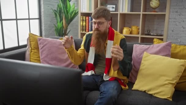 Ein Bärtiger Mann Mit Brille Sitzt Frustriert Auf Einem Sofa — Stockvideo