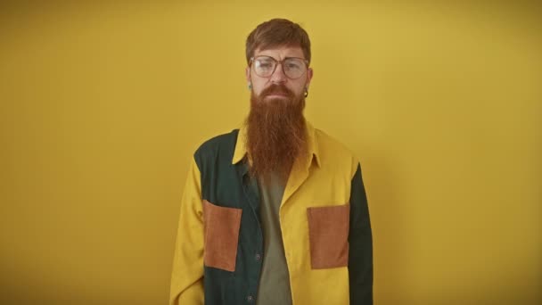 Tímido Joven Pelirrojo Con Gafas Pie Sobre Fondo Amarillo Está — Vídeo de stock