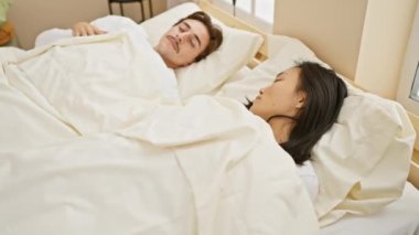 Irklar arası bir çift, bir erkek ve bir kadın, yatak odasında huzur içinde dinleniyor, bir yuva ortamında sevgi ve çeşitlilik sergiliyorlar..