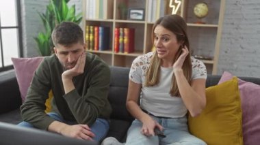 Endişeli bir kadın, üzgün erkeğini modern bir oturma odası ortamında rahatlatır, destekleyici bir ilişki anını betimler..