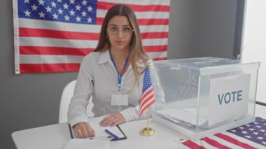 Amerika 'da arka planda Amerikan bayrağıyla çalışan Latin kökenli genç bir kadın..