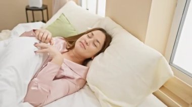 Huzurlu bir kadın, rahat bir evde huzur ve sükunet tasvir eden, aydınlık bir yatak odasında huzurlu bir uyku çeker..