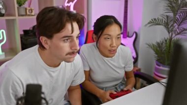 Irklar arası bir çift, neon ışıkları ve modern dekorları olan bir oyun odasında oyun oynamaktan hoşlanıyor..