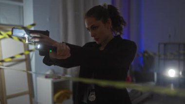 Odaklanmış bir kadın dedektif, el feneri ve silahla loş bir suç mahallini arıyor..