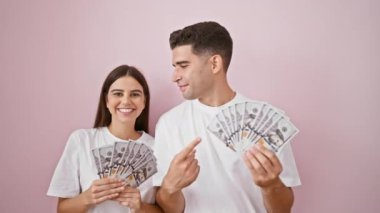Pembe arka planda Amerikan doları tutan neşeli bir çift refah ve ilişkiyi resmediyor..