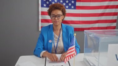 Neşeli Afro-Amerikan kadın, hükümet adayı, parlak bir şekilde gülümseyen ve seçmen koleji etkinliğinde onay için işaret veren.