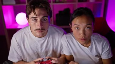 Irklar arası bir çift, bir erkek ve bir kadın evdeki çağdaş karanlık oyun odasında oyun oynuyorlar..