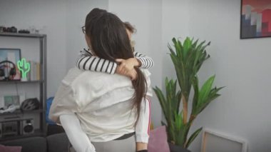 Sevgi dolu bir anne, genç oğlunu sıcak, modern bir oturma odasında kucaklıyor aile sevgisini ve sıcaklığını ifade ediyor..