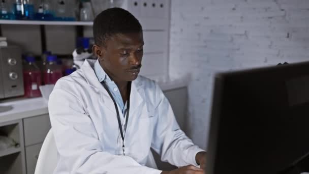 Hombre Africano Con Bata Laboratorio Trabajando Computadora Moderno Entorno Laboratorio — Vídeo de stock