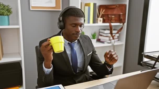 Bel Homme Africain Dans Les Écouteurs Bénéficie Café Dans Bureau — Video
