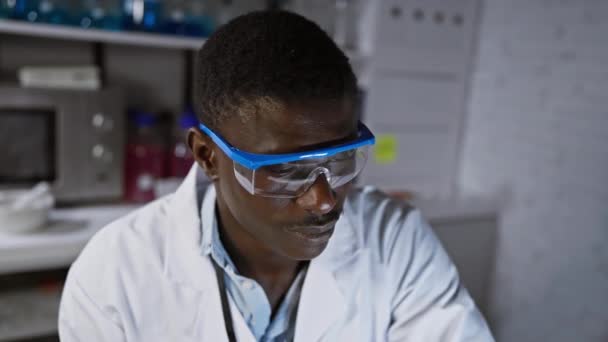 Африканський Вчений Чоловік Лабораторному Пальто Захисні Окуляри Сучасному Лабораторному Середовищі — стокове відео