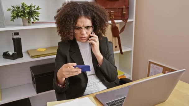 Zamartwiona Młoda Kobieta Biurze Sprawdza Kartę Kredytową Podczas Rozmowy Telefonicznej — Wideo stockowe