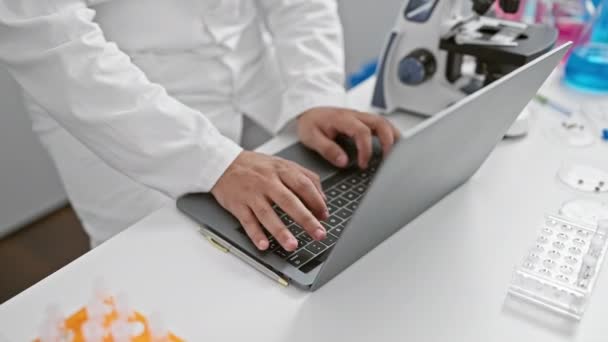 Młody Człowiek Fartuchu Laboratoryjnym Pracuje Pilnie Laptopie Nowoczesnym Laboratorium Otoczony — Wideo stockowe