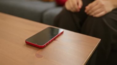 Genç bir kadın evde akıllı bir telefonla iletişim kuruyor, modern kapalı alan bağlantısını yakalıyor..