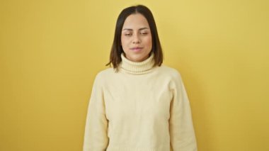 Süveter giyen genç ve güzel bir İspanyol kadın kollarını kaldırıp gözleri açık bir şekilde başarıyı kutluyor ve şaşırıyor. Kazanan konsept izole edilmiş sarı arkaplan