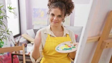 Kıvırcık saçlı neşeli İspanyol ressam stüdyo başarısından dolayı başparmak kaldırıyor.!