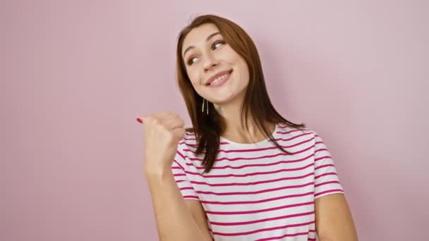 치어리 줄무늬 티셔츠에 반짝이 측면을 가리키는 행복을 세련된 분홍색 배경에 — 비디오