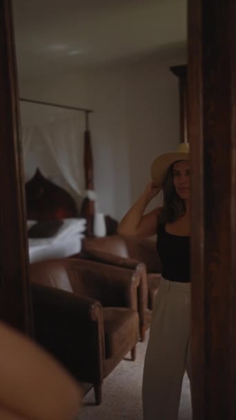 一位戴着帽子的年轻女子在一个舒适的客厅里热情地笑着 这反映了一个宁静的家的气氛 — 图库视频影像