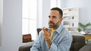 Profesyonel ortamında yakışıklı bir İspanyol. Cep telefonu, dövmesi, modern ofisi, iletişimi, yetişkin, erkek..