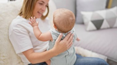 Annesinin sevgi dolu gülümsemesi, kızıyla birlikte evde rahat bir hayat sürerken neşeli bir kahkahayla gülmesi.