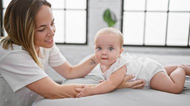 Anne ve kız, eğlenceli, sıradan bir oyun oynuyorlar yatak odasında oturuyorlar, havalı ve kendinden emin görünüyorlar, neşe, mutluluk ve güzel, pozitif bir yaşam tarzları var..