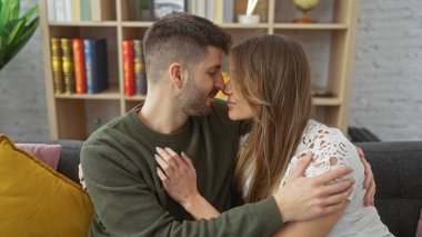 Sevgi dolu bir çift, sıcak bir oturma odasında kucaklaşır. Sıcaklık, mutluluk ve kadınla erkek arasında güçlü bir bağ vardır..