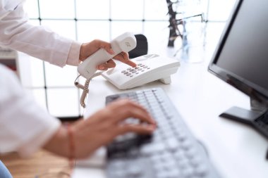Young arab woman pharmacist using telephone and computer at pharmacy