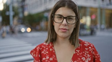 Gözlüklü, kendinden emin İspanyol kadın Tokyo 'nun canlı şehir caddesinde dikilip şehir mimarisine karşı bir portre çiziyor..