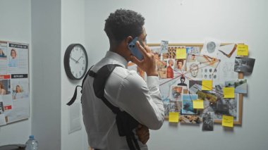 A man in a detective's office talks on the phone beside an evidence board with photos and notes. clipart