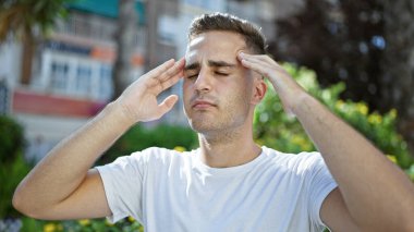 Şehrin dışında kederli bir ifadeyle başını tutan stresli, genç İspanyol bir adam..