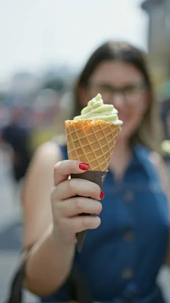 戴着眼镜的快乐而美丽的他的惊慌失措的女人快乐地品尝着一个美味的冰激凌圆锥 在繁忙的慈惠外卖中 东京的夏日乐趣 图库照片