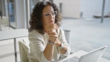 Modern bir ofis ortamında çalışırken bileği ağrıyan İspanyol kadın.