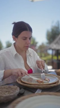 Odaklanmış genç bir kadın Bali 'de tropikal bir otelde yemek yiyor..