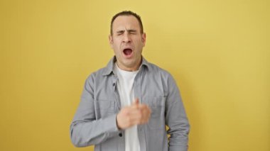 Çekici, tişörtlü, sıkıntıdan ve uykusuzluktan esneyen, ağzı açık genç bir İspanyol. Yorgunum, sarı arka planda yalnızım, sabahları tembellik ediyorum.