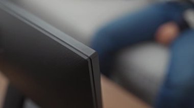 Çizgili kazaklı orta yaşlı bir kadın uzaktan kumandalı, rahat bir oturma odasında kanepede oturuyor..
