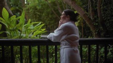 Cüppeli düşünceli bir kadın lüks bir balerin terasının sessizliğinin tadını çıkarıyor..