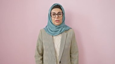 Soluk benizli, orta yaşlı, soğuk algınlığı veya bronşit belirtileri gösteren, pembe izole edilmiş arka planda öksüren İspanyol bir kadın. sağlık sorununa değiniliyor