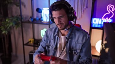 Yakışıklı, sakallı, gecenin bir yarısı karanlık bir odada video oyunu oynayan, heyecan ve odaklanma gösteren bir İspanyol..