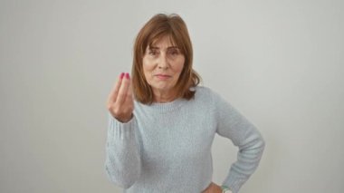 Süveter giyen kendinden emin orta yaşlı bir kadın İtalyan jestini eliyle vuruyor, izole edilmiş beyaz arka plana karşı sıradan bir poz veriyor..